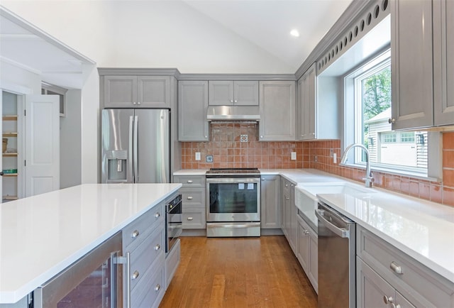 130 Sunset Ln, Greenport, NY 11944 - kitchen with appliances with stainless steel finishes, gray cabinetry, beverage cooler, lofted ceiling, and under cabinet range hood