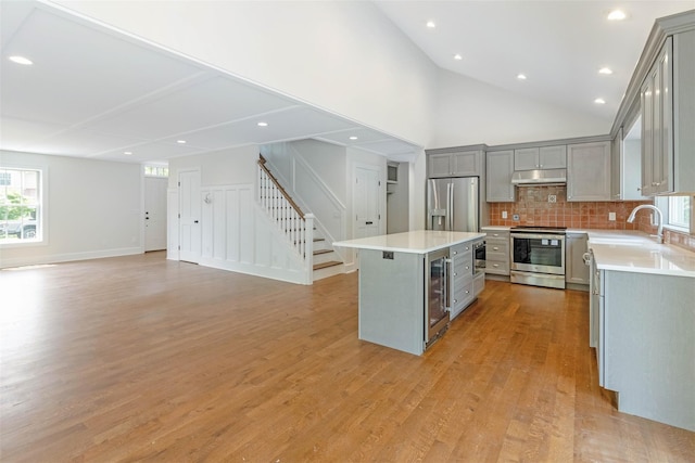 130 Sunset Ln, Greenport, NY 11944 - kitchen featuring gray cabinetry, stainless steel appliances, under cabinet range hood, light wood-style flooring, and light countertops