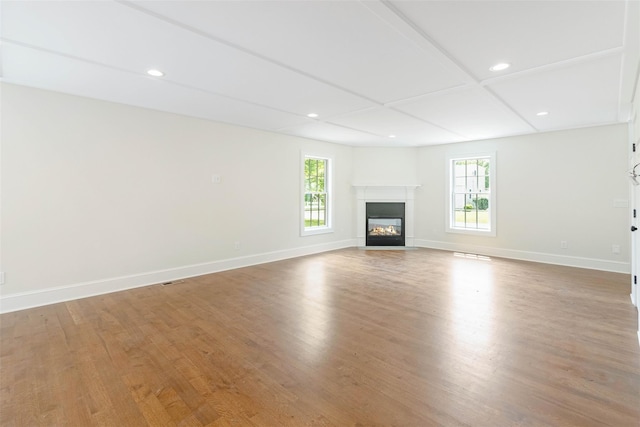 130 Sunset Ln, Greenport, NY 11944 - unfurnished living room with healthy amount of natural light, wood finished floors, recessed lighting, and a glass covered fireplace