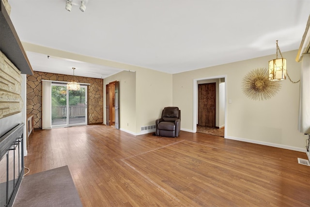 25 Tappan Ter, Briarcliff Manor, NY 10510 - unfurnished living room featuring wood finished floors, a chandelier, and a glass covered fireplace