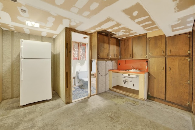 25 Tappan Ter, Briarcliff Manor, NY 10510 - kitchen with freestanding refrigerator, brown cabinets, and unfinished concrete flooring