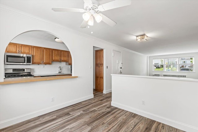 24 Ridge St N Unit 24-A, Rye Brook, NY 10573 - kitchen with appliances with stainless steel finishes, wood finished floors, tasteful backsplash, a ceiling fan, and brown cabinetry