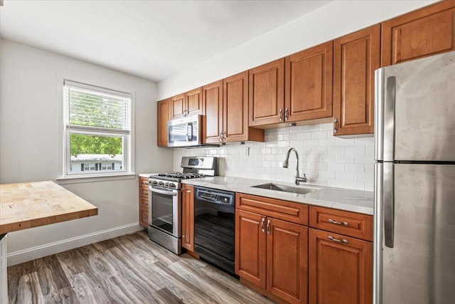 24 Ridge St N Unit 24-A, Rye Brook, NY 10573 - kitchen with stainless steel appliances, light wood-style flooring, backsplash, and brown cabinets