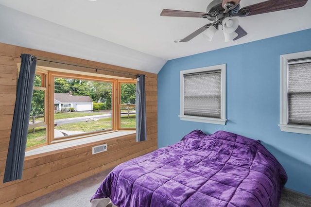 6 Youngs Ln, Setauket, NY 11733 - bedroom with carpet flooring, wood walls, lofted ceiling, and ceiling fan