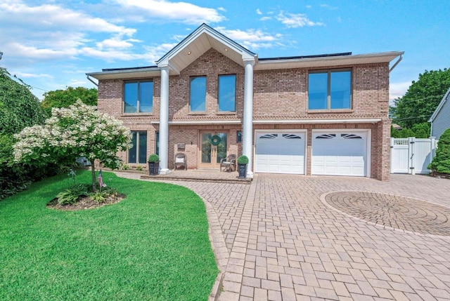 709 Demott Ct, Westbury, NY 11590 - view of front facade featuring curved driveway, brick siding, an attached garage, and a gate