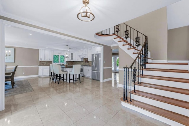 709 Demott Ct, Westbury, NY 11590 - stairway featuring a chandelier, tile patterned floors, crown molding, and recessed lighting