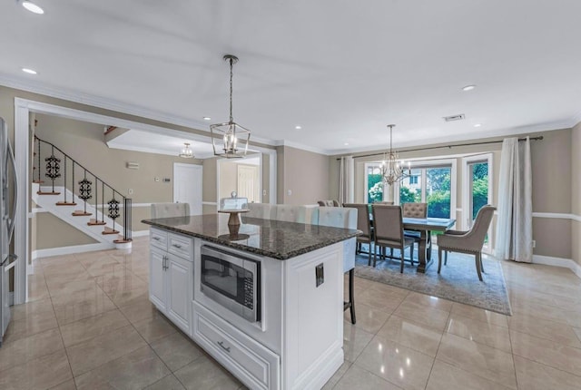 709 Demott Ct, Westbury, NY 11590 - kitchen featuring stainless steel appliances, crown molding, a center island, white cabinets, and light tile patterned floors