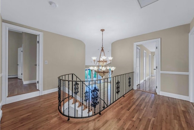 709 Demott Ct, Westbury, NY 11590 - hallway with wood finished floors, an upstairs landing, a chandelier, and baseboard heating