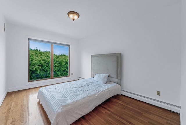 709 Demott Ct, Westbury, NY 11590 - bedroom featuring a baseboard radiator and wood finished floors
