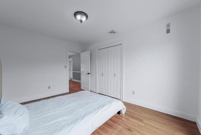 709 Demott Ct, Westbury, NY 11590 - unfurnished bedroom featuring wood finished floors and a closet