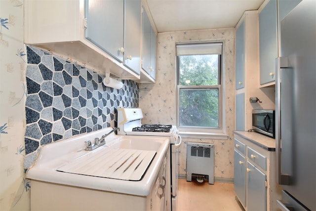 1 Georgia Ave Unit 3E, Bronxville, NY 10708 - kitchen with stainless steel appliances, light countertops, radiator, and backsplash