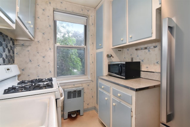 1 Georgia Ave Unit 3E, Bronxville, NY 10708 - kitchen featuring appliances with stainless steel finishes, radiator, light countertops, and wallpapered walls