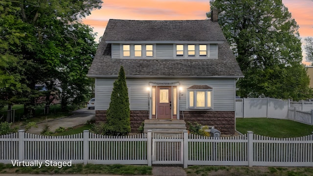 26 Rosedale Ave, Freeport, NY 11520 - view of front of home with stone siding, a chimney, and a fenced front yard