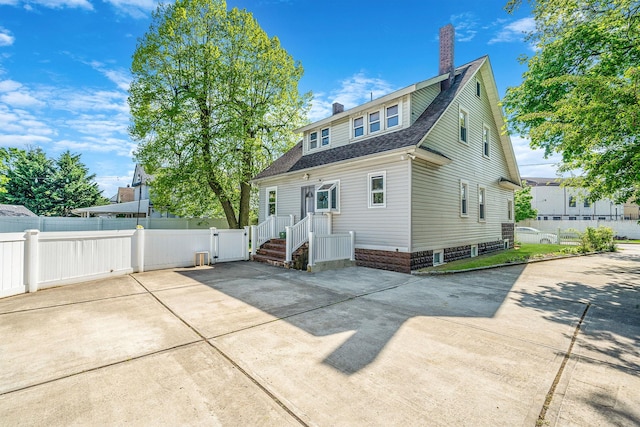 26 Rosedale Ave, Freeport, NY 11520 - back of property with a chimney, roof with shingles, and a gate
