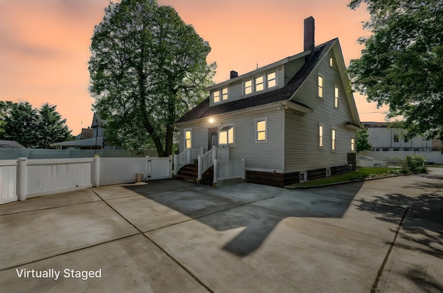 26 Rosedale Ave, Freeport, NY 11520 - back of property at dusk with a chimney and a patio