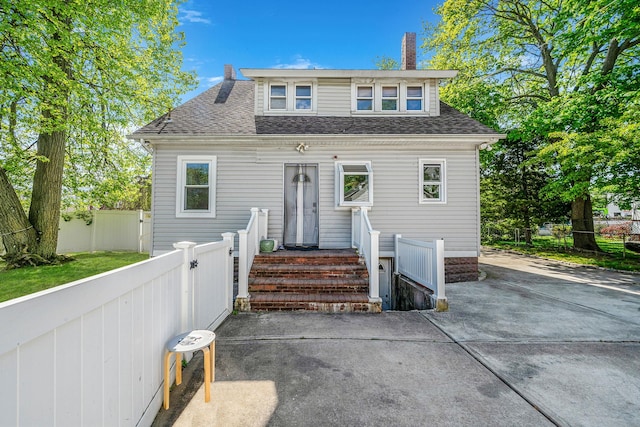 26 Rosedale Ave, Freeport, NY 11520 - view of front of property with a chimney, a shingled roof, and a patio