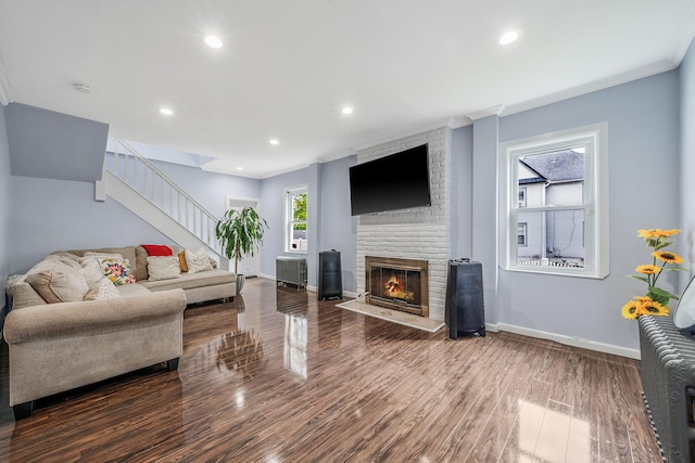 26 Rosedale Ave, Freeport, NY 11520 - living area featuring ornamental molding, radiator, stairway, a fireplace, and wood finished floors