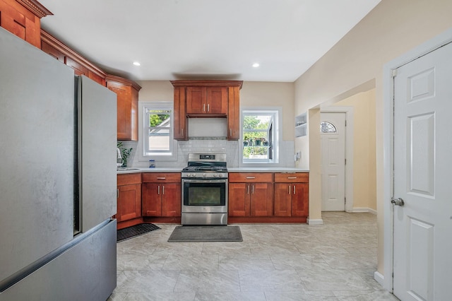 26 Rosedale Ave, Freeport, NY 11520 - kitchen with stainless steel range with gas cooktop, freestanding refrigerator, tasteful backsplash, light countertops, and recessed lighting