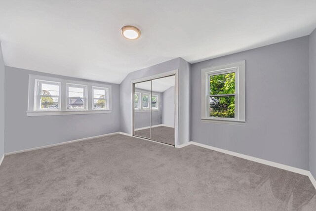 26 Rosedale Ave, Freeport, NY 11520 - unfurnished bedroom featuring vaulted ceiling, carpet floors, multiple windows, and a closet