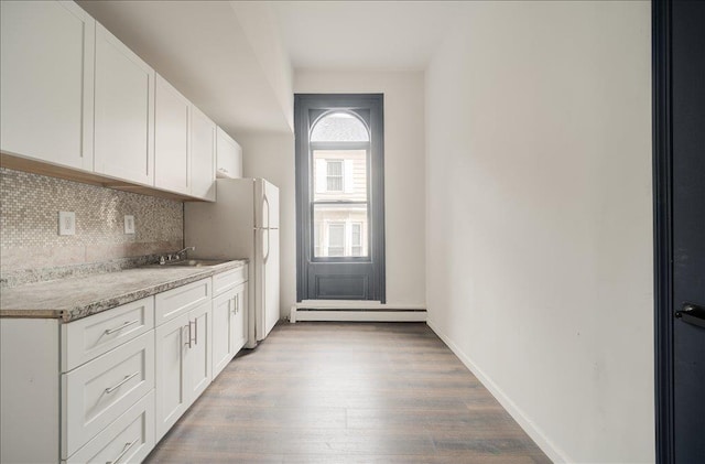 97 E Main St, Middletown, NY 10940 - kitchen featuring tasteful backsplash, light wood finished floors, freestanding refrigerator, white cabinetry, and baseboard heating