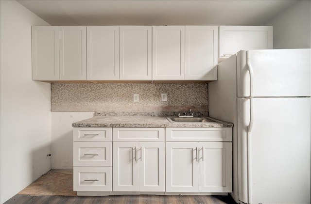 97 E Main St, Middletown, NY 10940 - kitchen with freestanding refrigerator, white cabinetry, tasteful backsplash, and wood finished floors