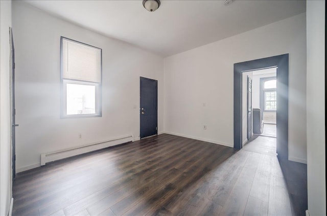 97 E Main St, Middletown, NY 10940 - empty room featuring a baseboard heating unit and dark wood-style floors