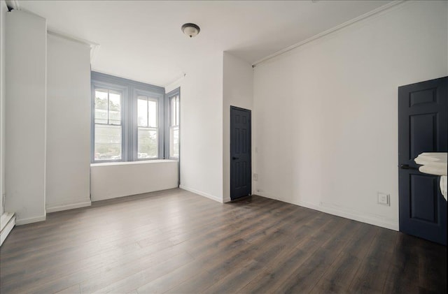 97 E Main St, Middletown, NY 10940 - spare room featuring dark wood-style flooring, crown molding, and a baseboard heating unit