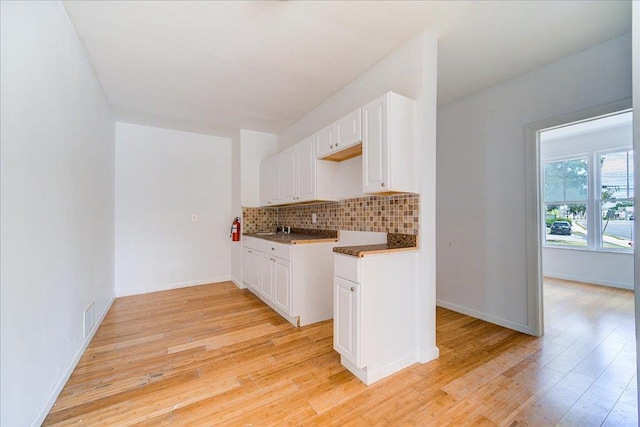 221 E Main St, Middletown, NY 10940 - kitchen with decorative backsplash, light wood finished floors, and white cabinets