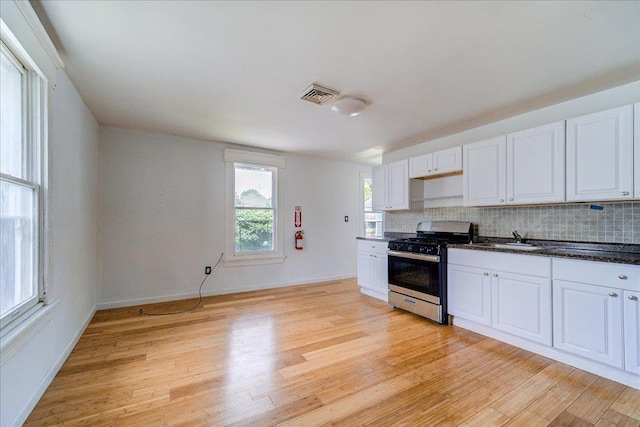 221 E Main St, Middletown, NY 10940 - kitchen with stainless steel gas range oven, light wood-type flooring, and decorative backsplash