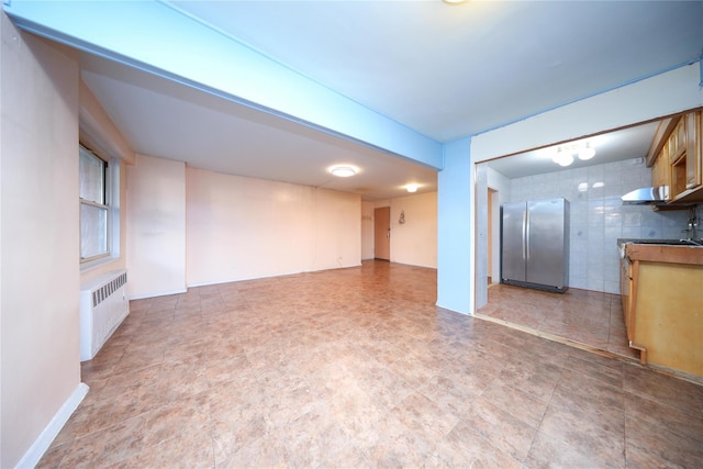1935 Shore Pkwy Unit 1F, Brooklyn, NY 11214 - unfurnished living room featuring radiator heating unit and tile walls