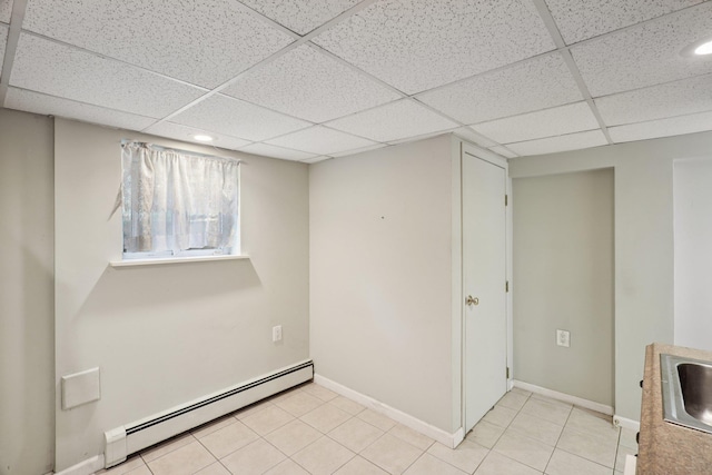 65 Winston Dr, Smithtown, NY 11787 - basement featuring a baseboard heating unit, a paneled ceiling, light tile patterned floors, and recessed lighting