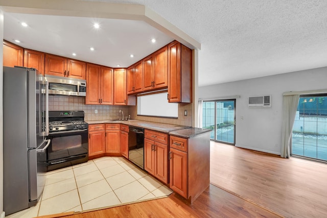 504 Julius Rd Unit 7C, College Point, NY 11356 - kitchen with black appliances, light wood-style floors, tasteful backsplash, a wall mounted air conditioner, and brown cabinetry