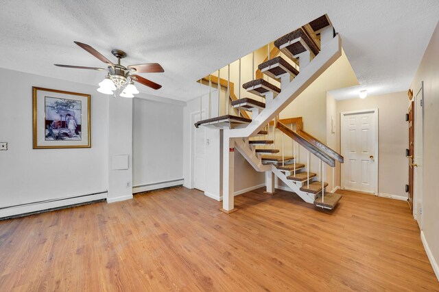 504 Julius Rd Unit 7C, College Point, NY 11356 - stairway featuring baseboard heating, ceiling fan, wood finished floors, a textured ceiling, and a baseboard heating unit