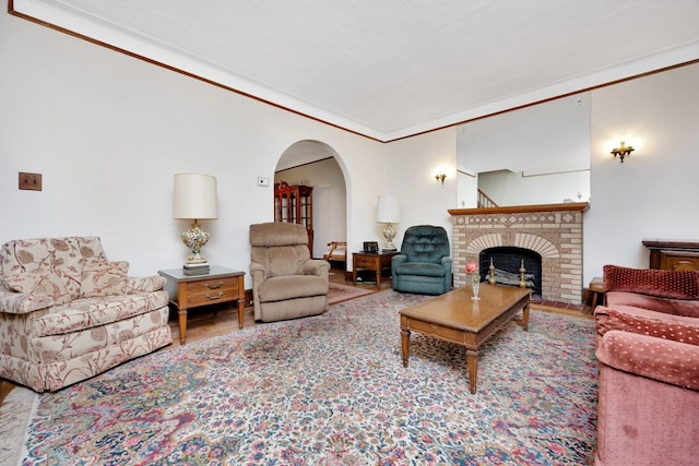 64-66 82nd Pl, Middle Village, NY 11379 - living room featuring arched walkways, a brick fireplace, wood finished floors, and crown molding
