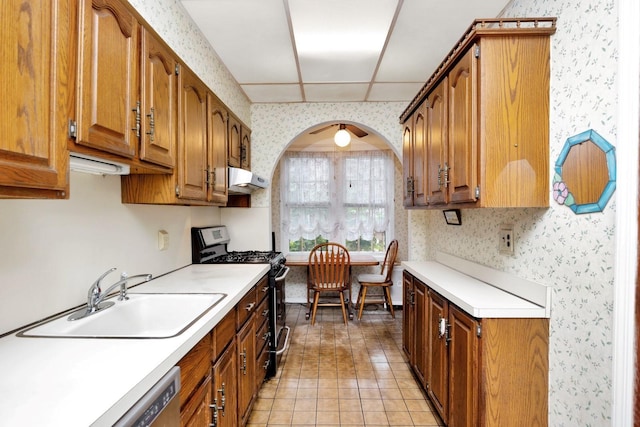 64-66 82nd Pl, Middle Village, NY 11379 - kitchen featuring gas range, wallpapered walls, light countertops, brown cabinets, and under cabinet range hood