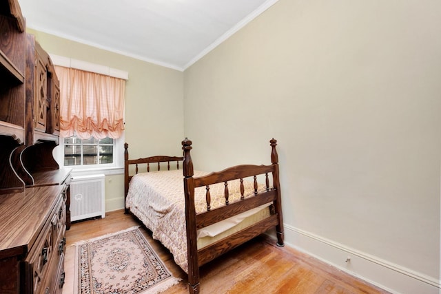 64-66 82nd Pl, Middle Village, NY 11379 - bedroom featuring radiator heating unit, light wood-style flooring, and ornamental molding