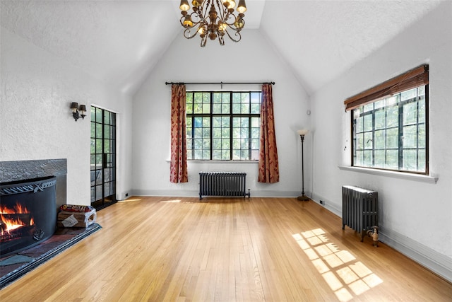 1 Highwood Way, Larchmont, NY 10538 - unfurnished living room with radiator heating unit, a chandelier, a warm lit fireplace, wood finished floors, and vaulted ceiling