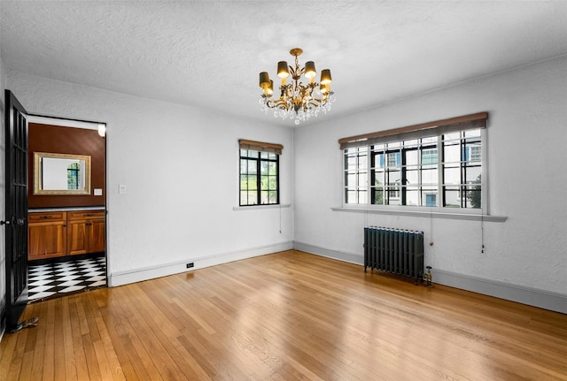 1 Highwood Way, Larchmont, NY 10538 - unfurnished room with radiator heating unit, a chandelier, hardwood / wood-style flooring, and a textured ceiling