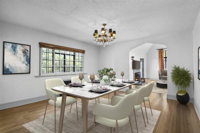 1 Highwood Way, Larchmont, NY 10538 - dining area with a chandelier, hardwood / wood-style flooring, a textured ceiling, arched walkways, and a textured wall