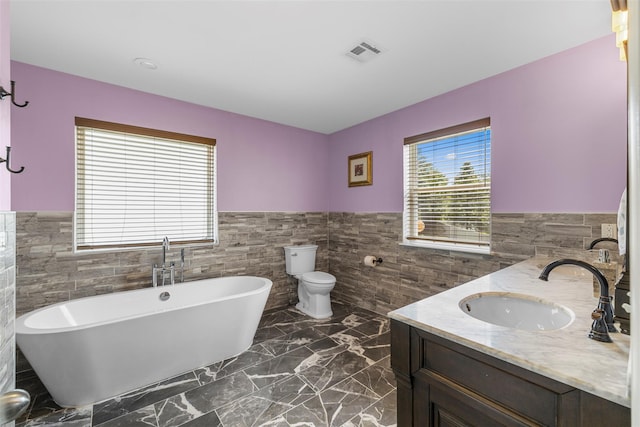 9 June Rd, Chester, NY 10918 - full bathroom with tile walls, a wainscoted wall, a freestanding tub, double vanity, and marble finish floors