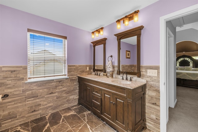 9 June Rd, Chester, NY 10918 - ensuite bathroom featuring tile walls, a wainscoted wall, double vanity, and marble finish floors