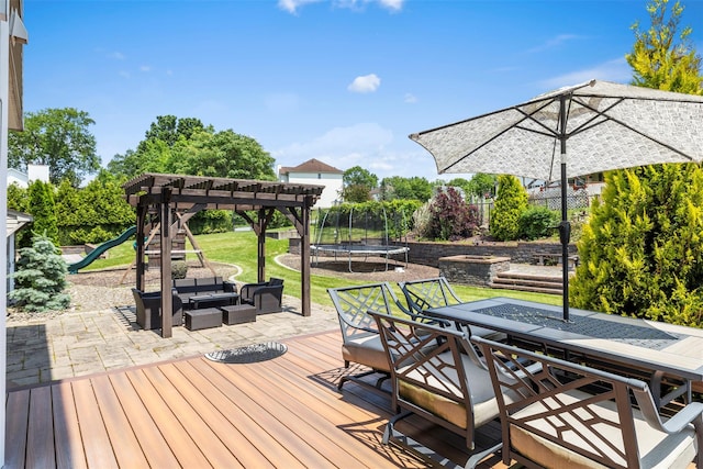 9 June Rd, Chester, NY 10918 - deck featuring a trampoline, outdoor dining area, a patio area, a lawn, and a playground