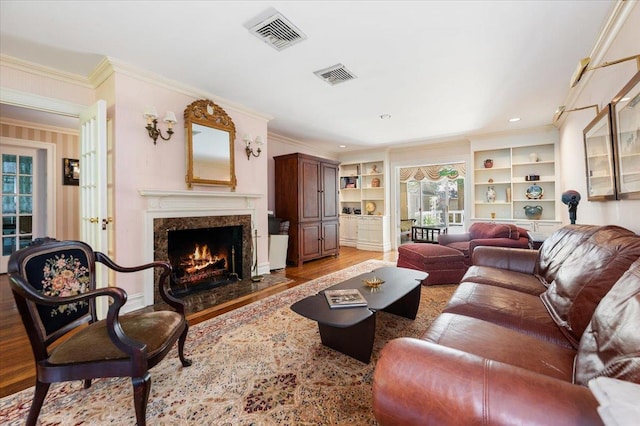 34 Elm St, Great Neck, NY 11021 - living area featuring light wood-style floors, ornamental molding, a fireplace, built in features, and recessed lighting