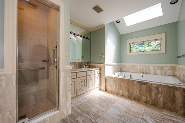 34 Elm St, Great Neck, NY 11021 - full bathroom with a skylight, vanity, a bath, a stall shower, and wainscoting