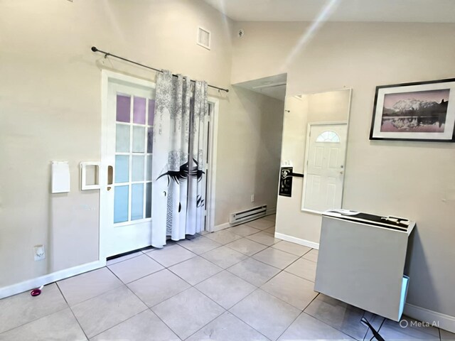 42 Oak Dr, Riverhead, NY 11901 - unfurnished room featuring a baseboard heating unit, light tile patterned floors, and vaulted ceiling
