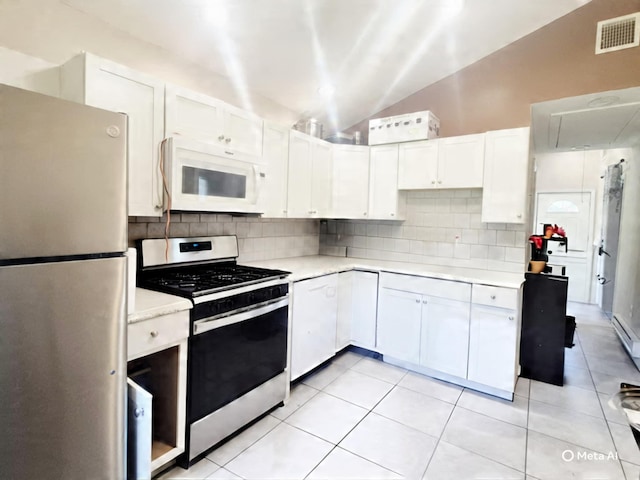 42 Oak Dr, Riverhead, NY 11901 - kitchen featuring stainless steel appliances, lofted ceiling, light countertops, backsplash, and white cabinets