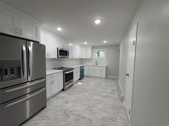 9 Holt St, Amityville, NY 11701 - kitchen featuring appliances with stainless steel finishes, light marble finish flooring, light countertops, recessed lighting, and white cabinetry