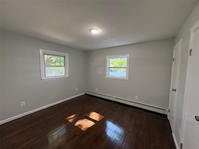 9 Holt St, Amityville, NY 11701 - empty room featuring a baseboard heating unit, plenty of natural light, and dark wood-style floors