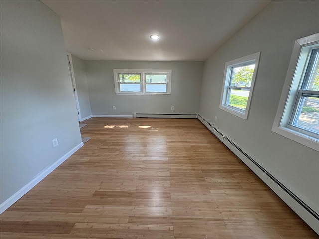 9 Holt St, Amityville, NY 11701 - spare room with a baseboard heating unit, light wood-type flooring, vaulted ceiling, and recessed lighting
