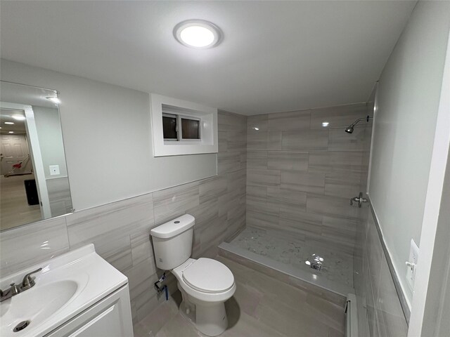 9 Holt St, Amityville, NY 11701 - bathroom with a tile shower, vanity, and tile walls